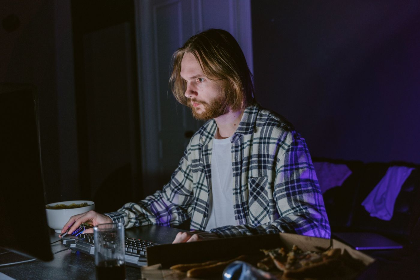 IT engineer focused on a computer screen late at night